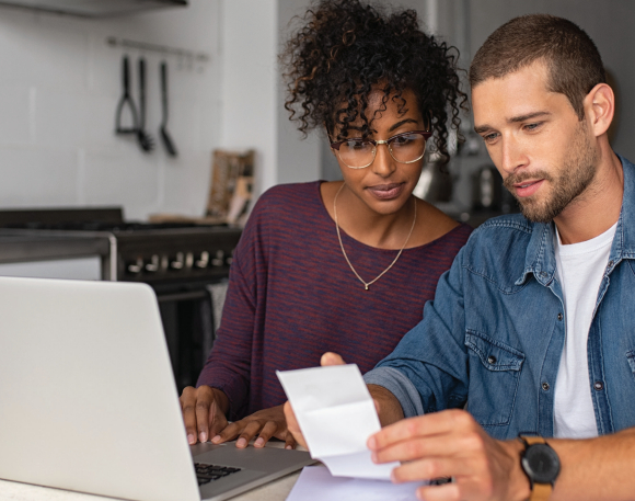 Couple looking at a laptop and a bill